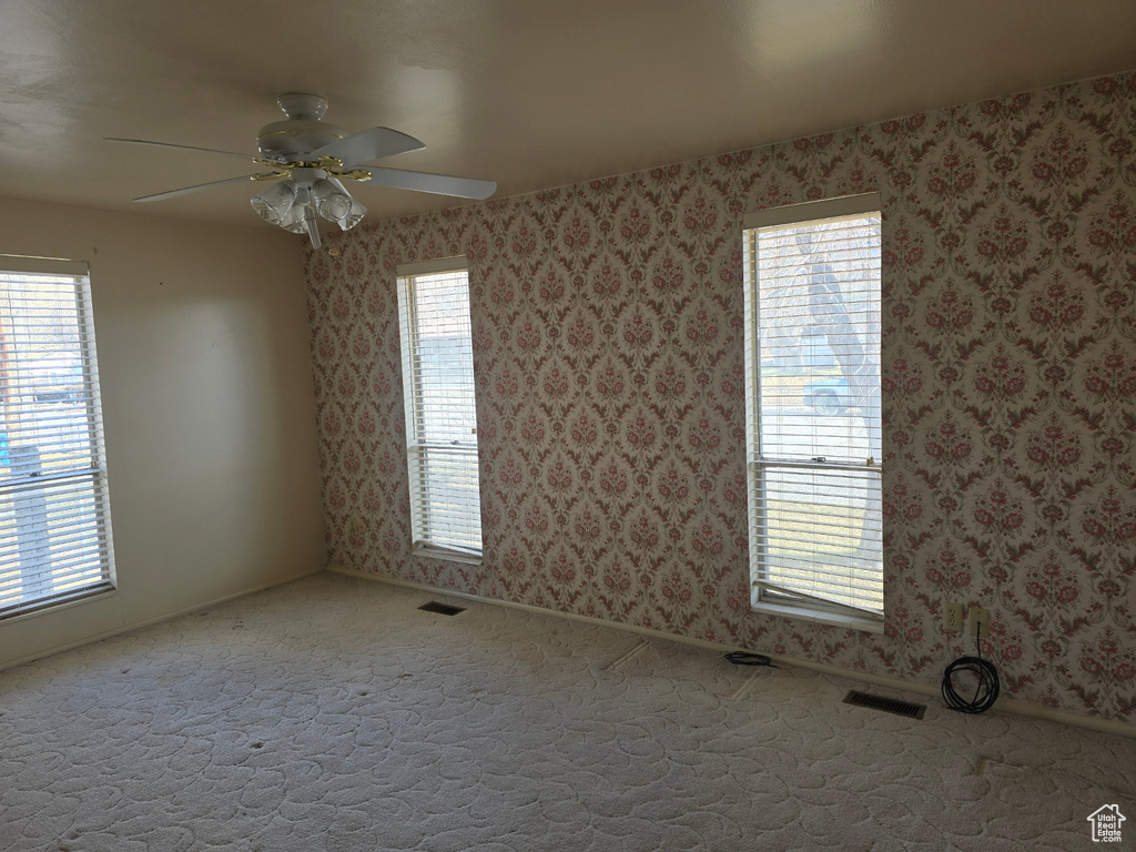 Empty room featuring carpet floors and ceiling fan