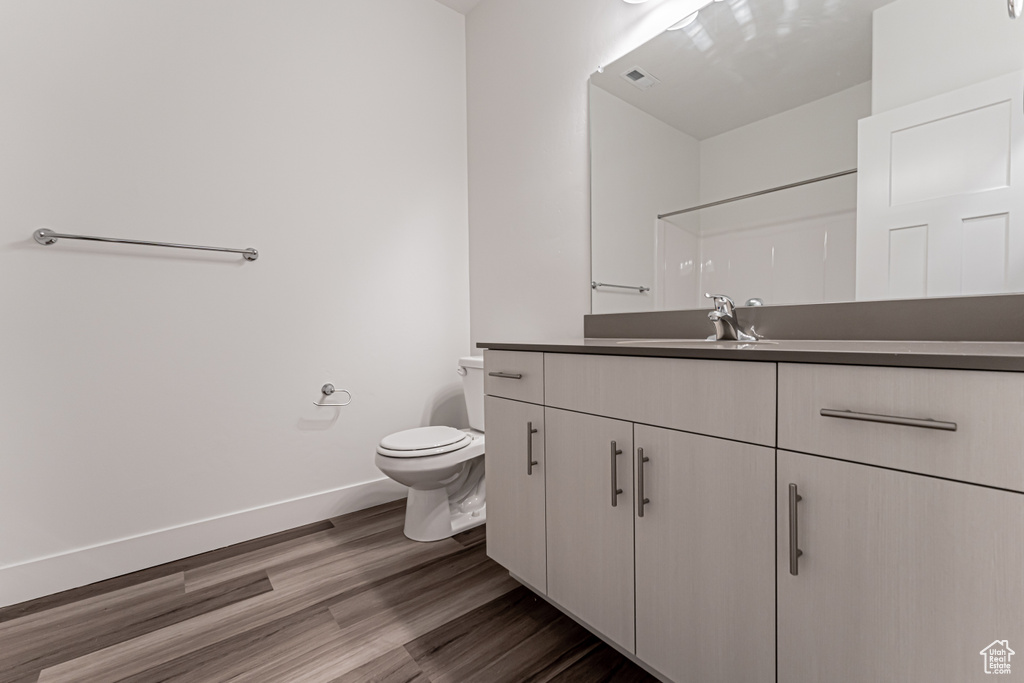 Full bath with vanity and wood finished floors