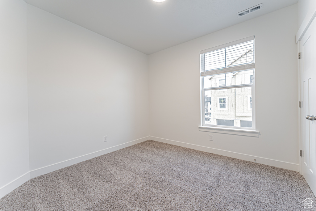 Carpeted empty room featuring baseboards