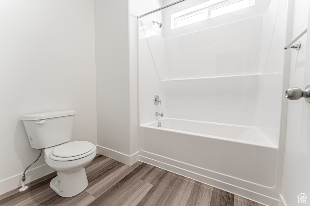 Full bath featuring wood finished floors and bathing tub / shower combination