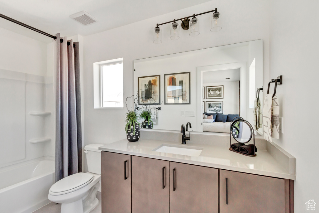 Full bathroom featuring vanity, toilet, and shower / bath combination with curtain