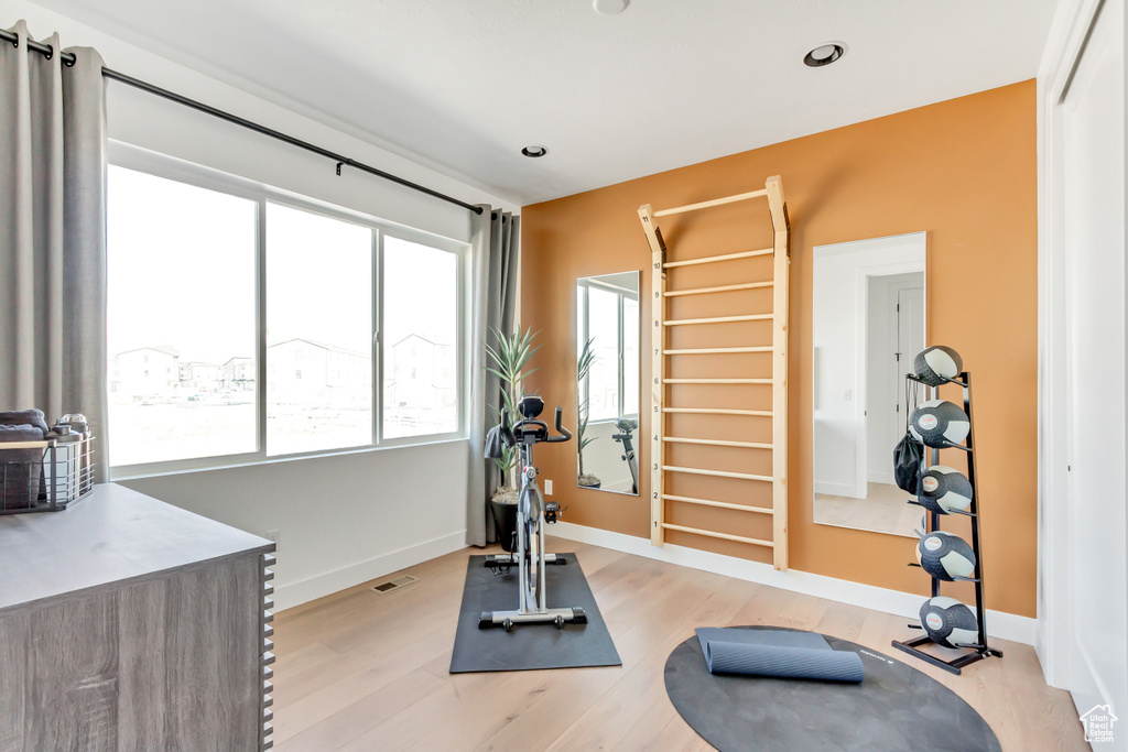 Exercise room with light hardwood / wood-style flooring
