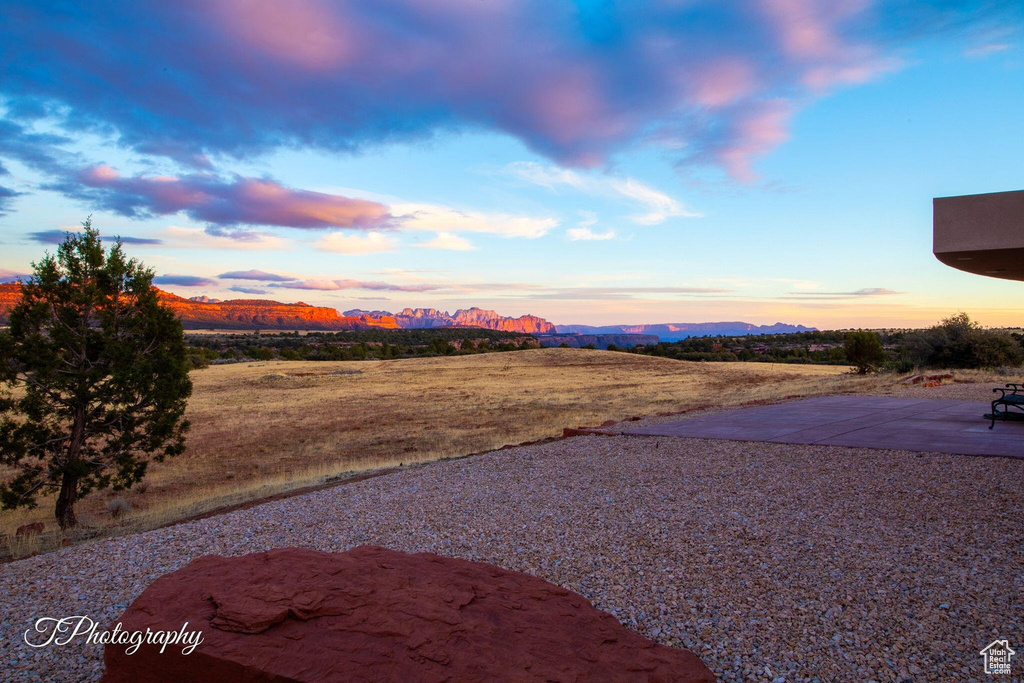 Yard at dusk with a mountain view and a patio area