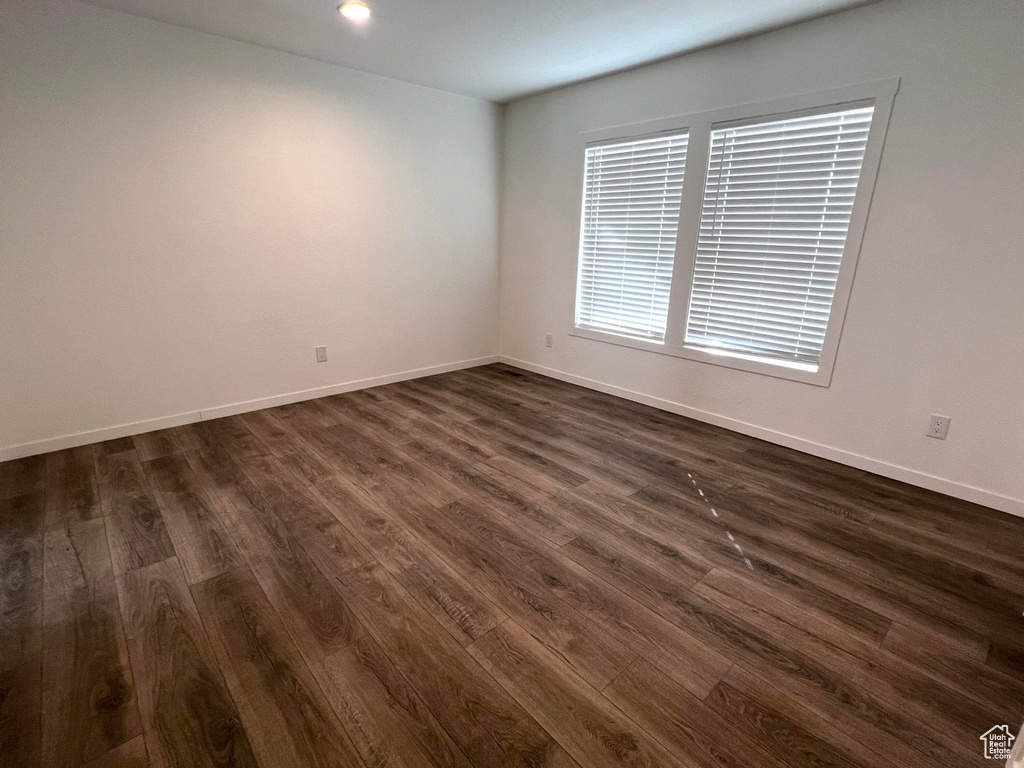 Spare room with dark wood-type flooring