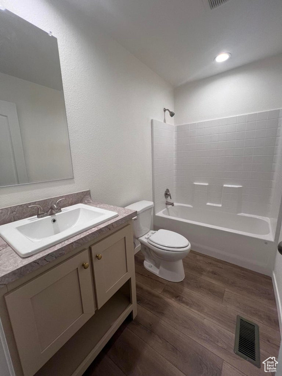 Full bathroom featuring toilet, bathtub / shower combination, wood-type flooring, and vanity