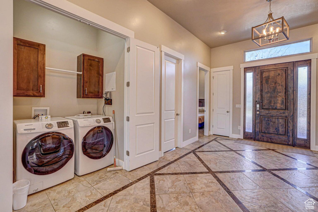 Foyer entrance featuring a notable chandelier and washing machine and dryer