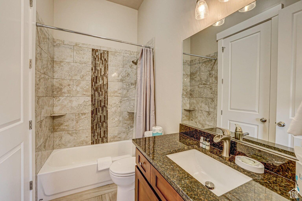 Full bathroom with vanity, toilet, and shower / bath combo with shower curtain