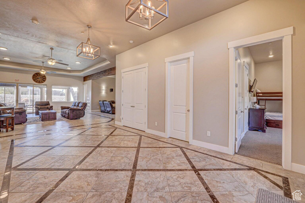 Hallway with a chandelier and a tray ceiling