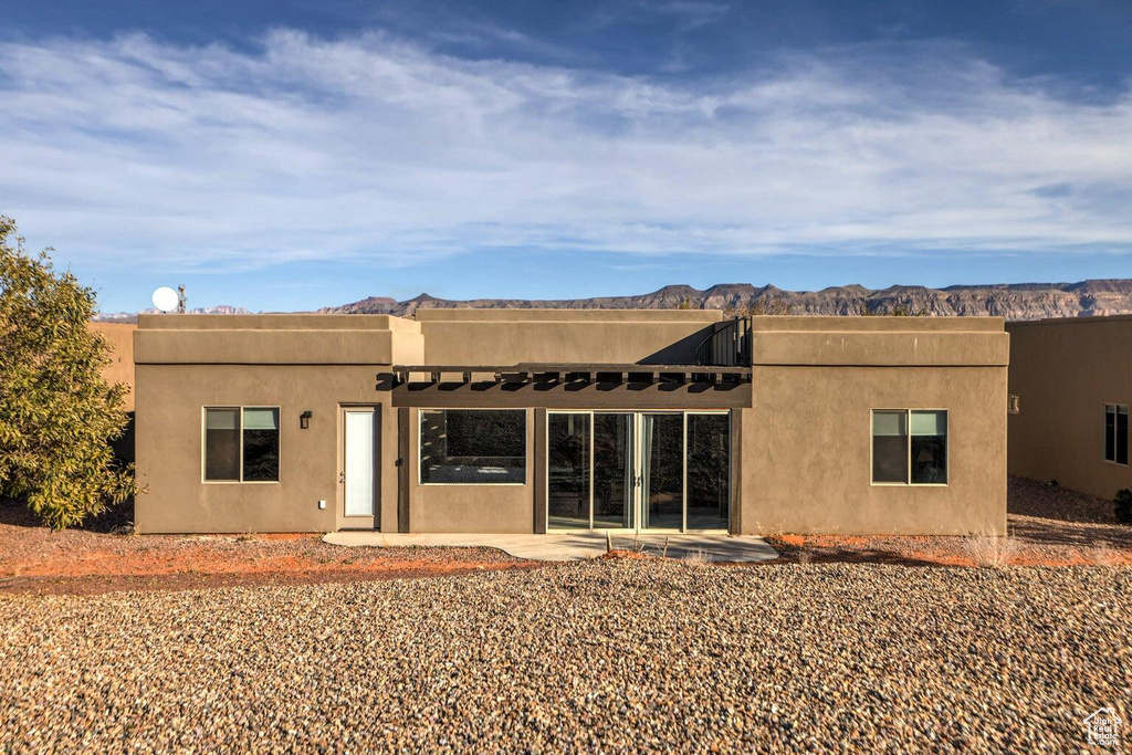 Rear view of property featuring a mountain view and a patio area