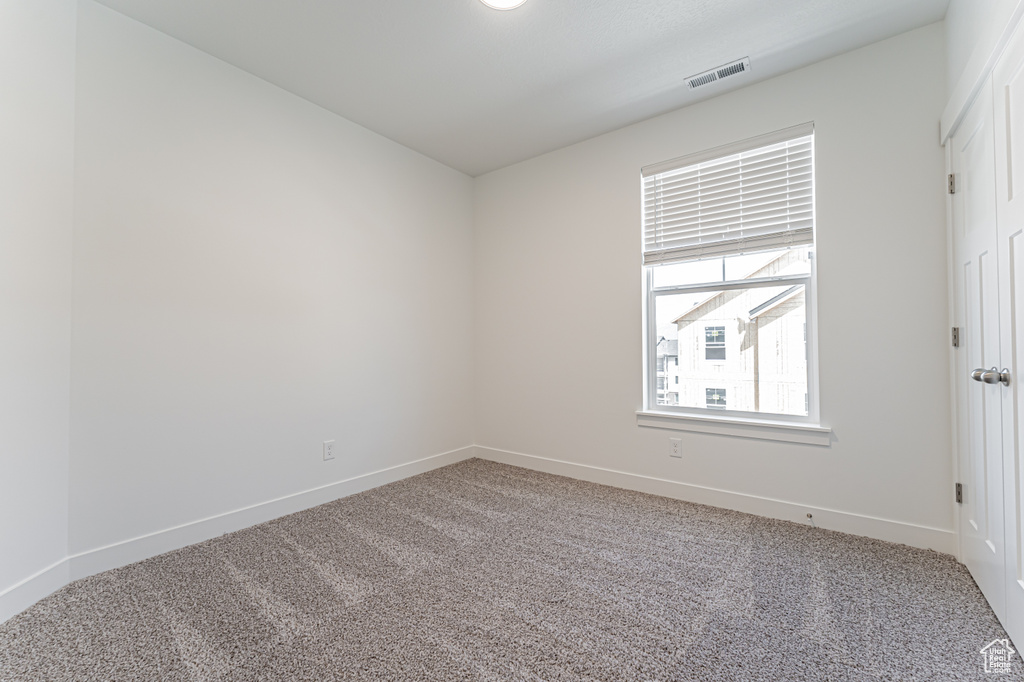 Carpeted empty room with baseboards