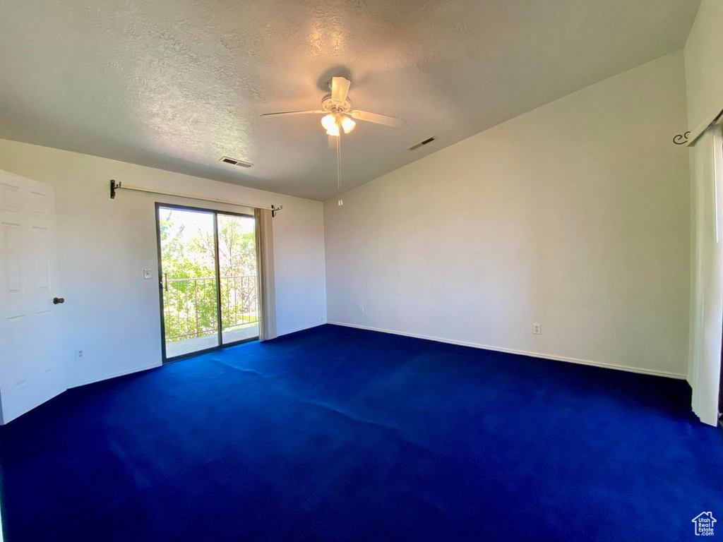 Carpeted spare room featuring a textured ceiling and ceiling fan