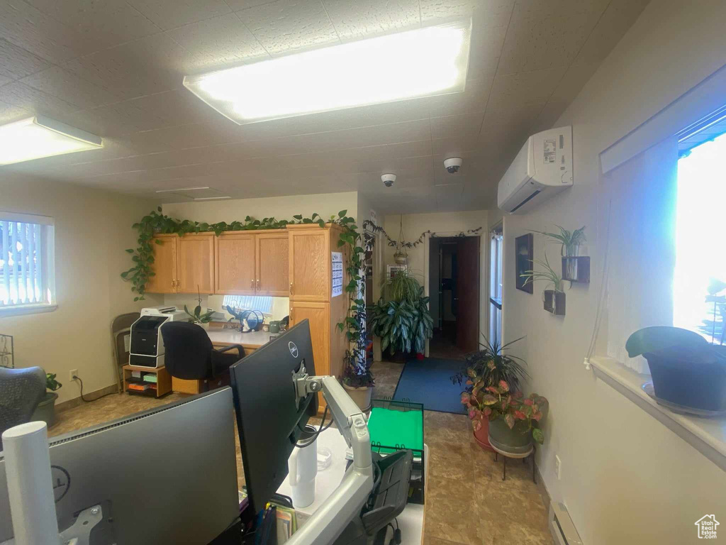 Interior space featuring light brown cabinets, a healthy amount of sunlight, and an AC wall unit