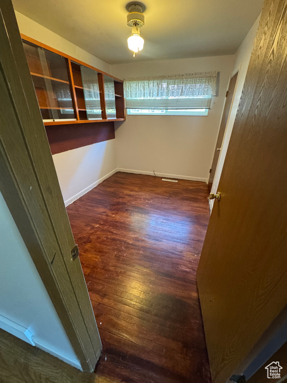 Unfurnished room with wood finished floors and baseboards