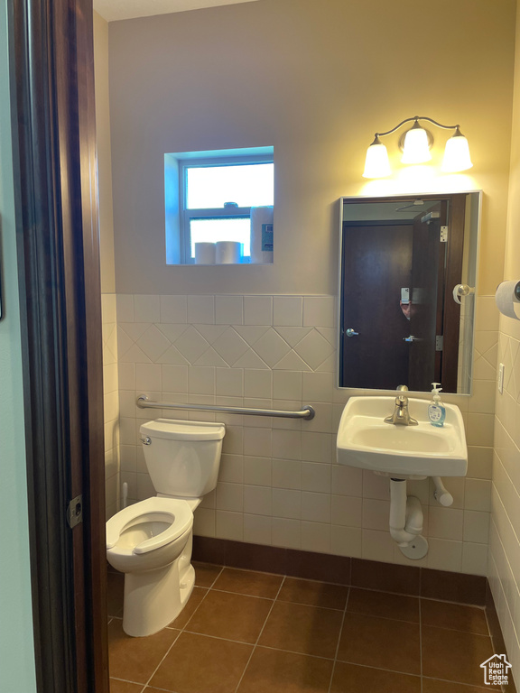Bathroom with sink, toilet, tile walls, and tile patterned flooring