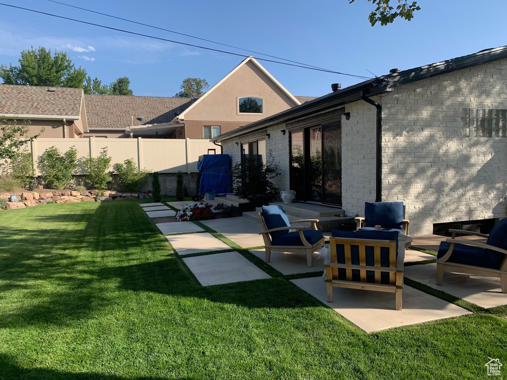 Back of house with a patio area and a yard