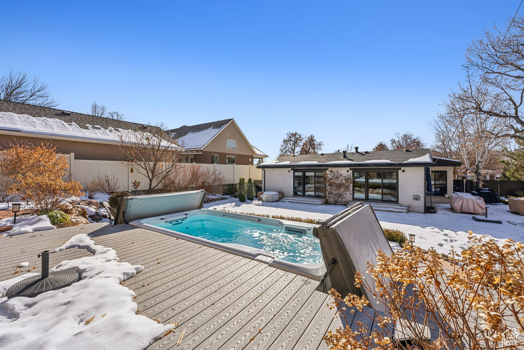 Snow covered pool featuring a deck