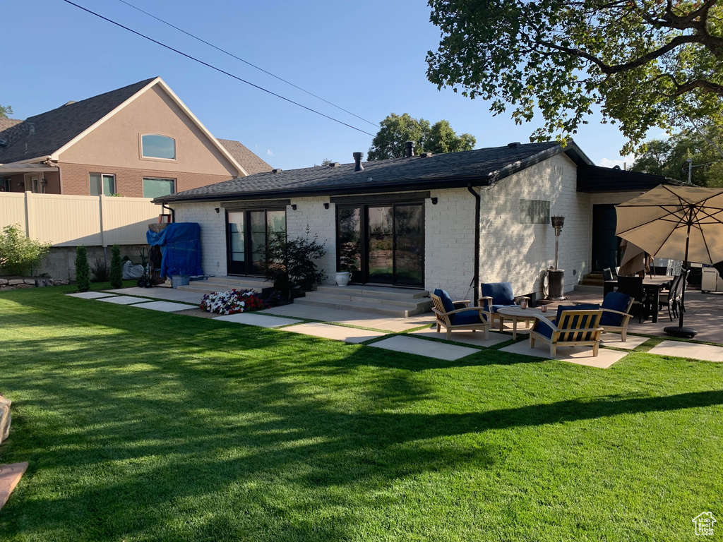 Rear view of property with a patio area and a yard