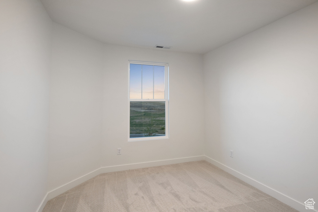 Empty room with baseboards and light colored carpet