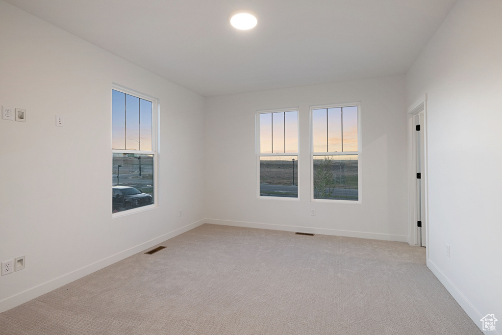 Empty room featuring light carpet and baseboards