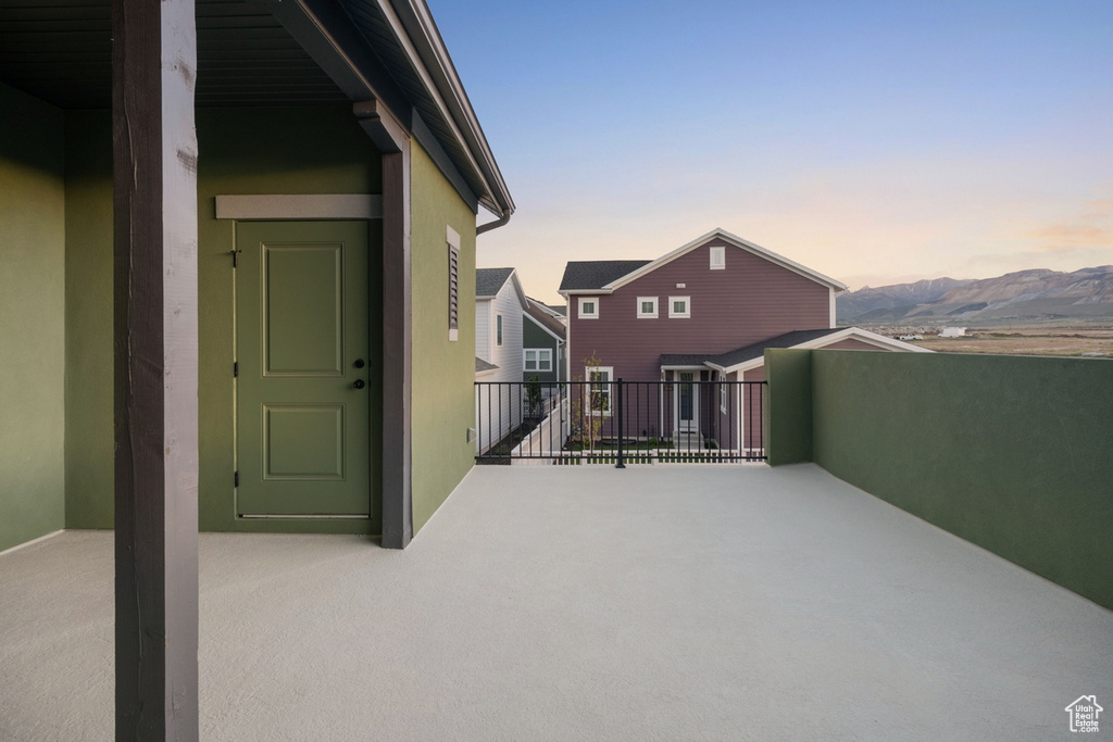 Patio terrace at dusk featuring a balcony