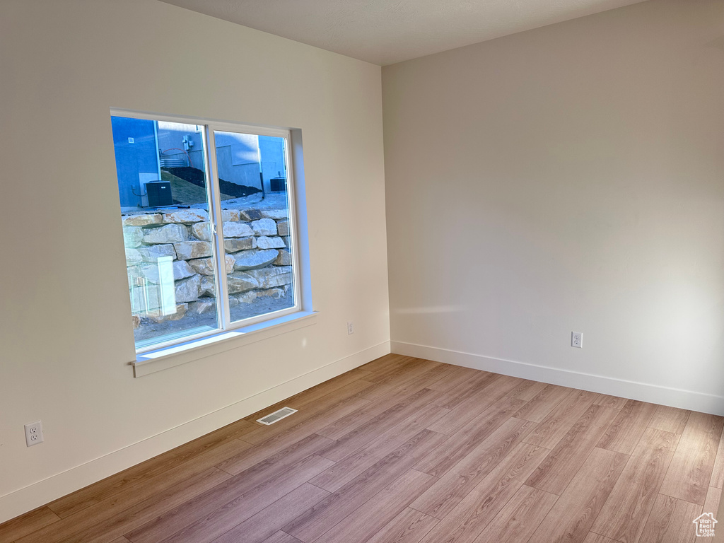 Empty room with light hardwood / wood-style flooring