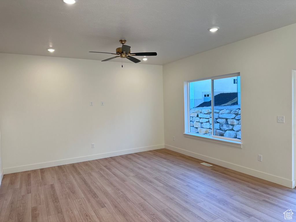 Unfurnished room with light hardwood / wood-style flooring and ceiling fan