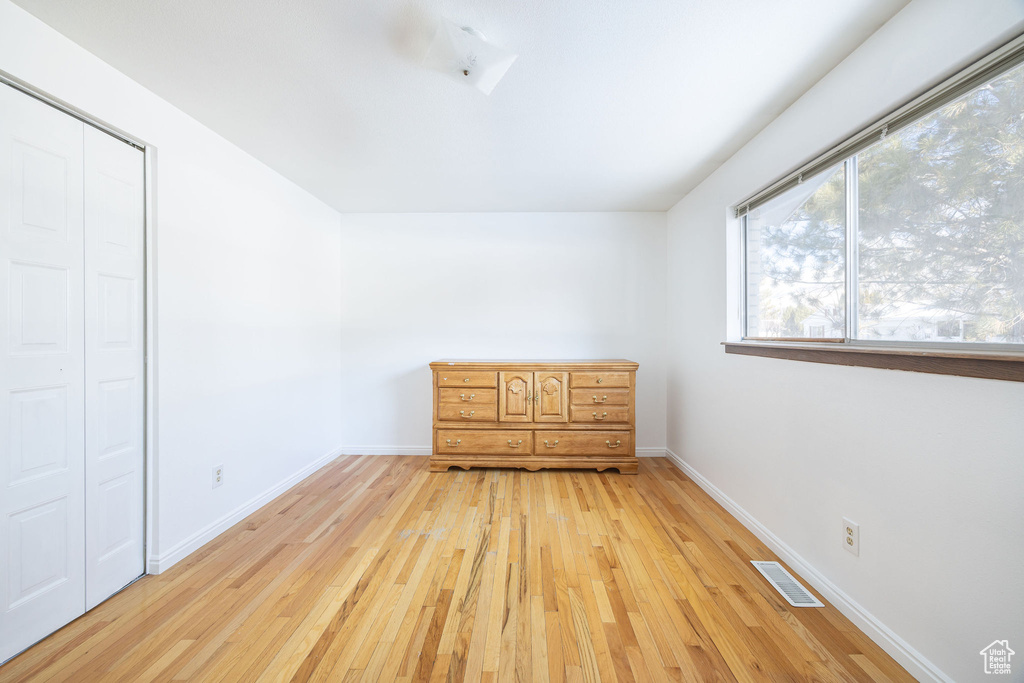 Unfurnished bedroom with a closet and light hardwood / wood-style floors