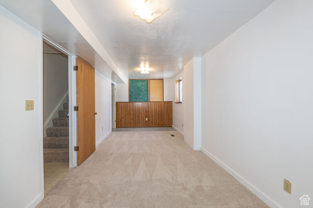 Hallway featuring light colored carpet