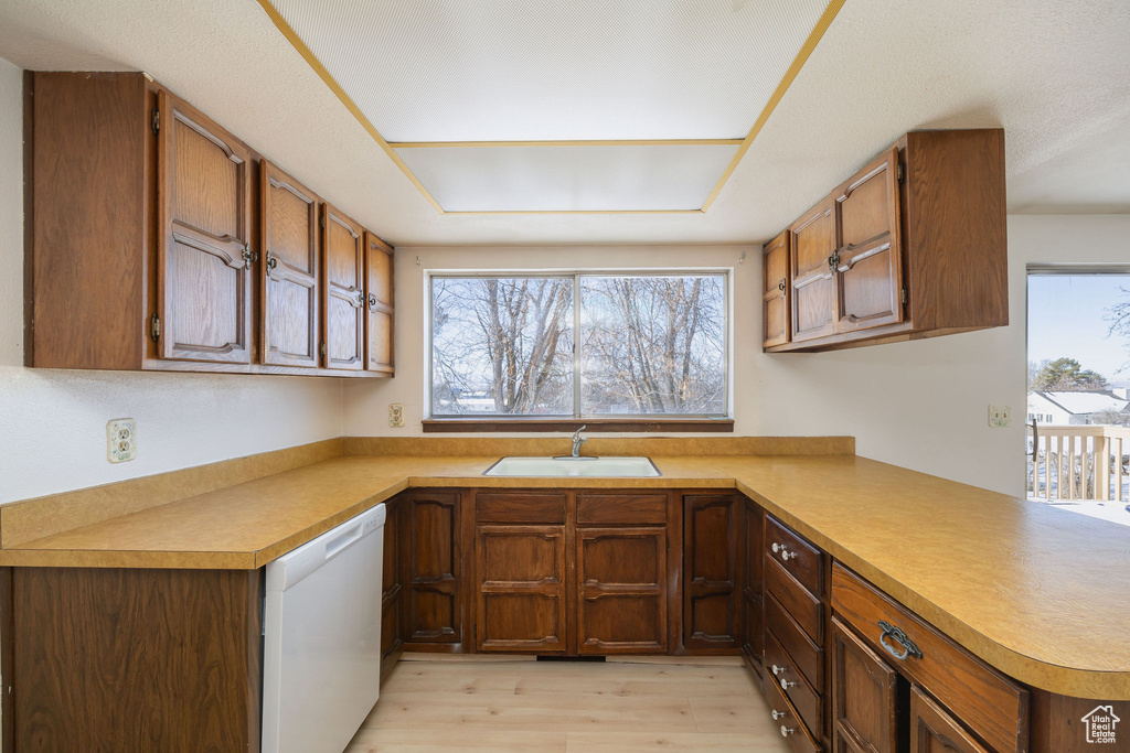 Kitchen featuring sink, light hardwood / wood-style flooring, kitchen peninsula, and dishwasher