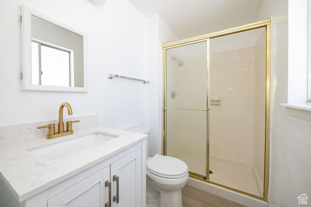 Bathroom with vanity, toilet, walk in shower, and hardwood / wood-style floors