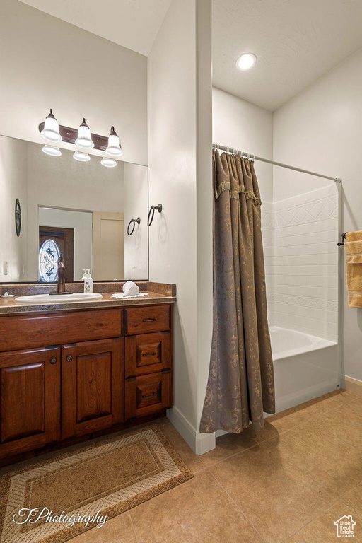 Bathroom with vanity, shower / bath combination with curtain, and tile patterned flooring