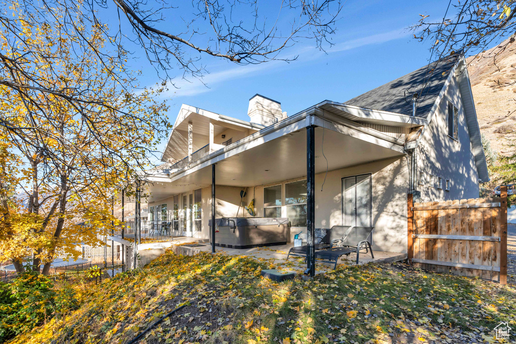 Rear view of property featuring a hot tub