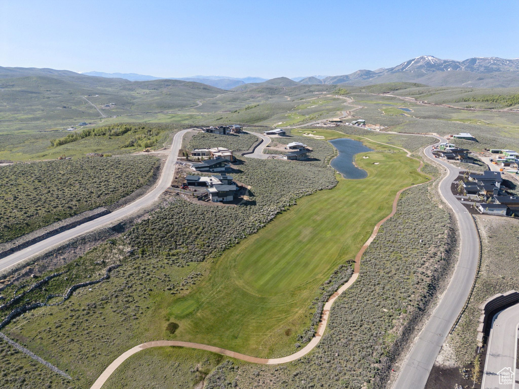 Aerial view of property and surrounding area with a water and mountain view and a golf club