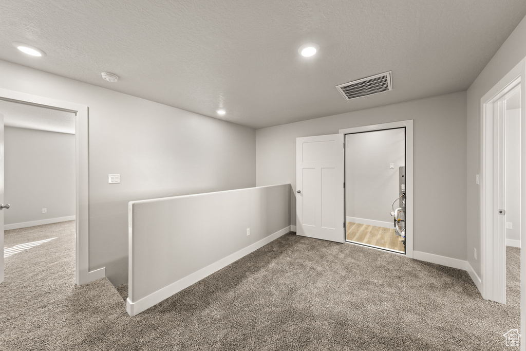 Carpeted spare room with a textured ceiling