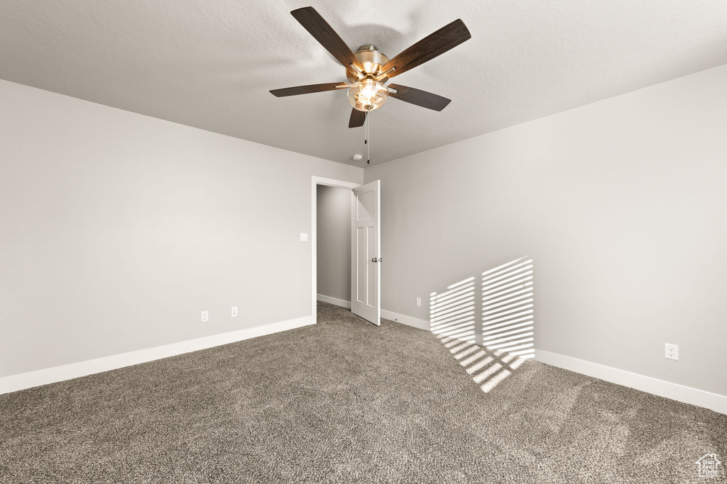 Carpeted spare room with ceiling fan