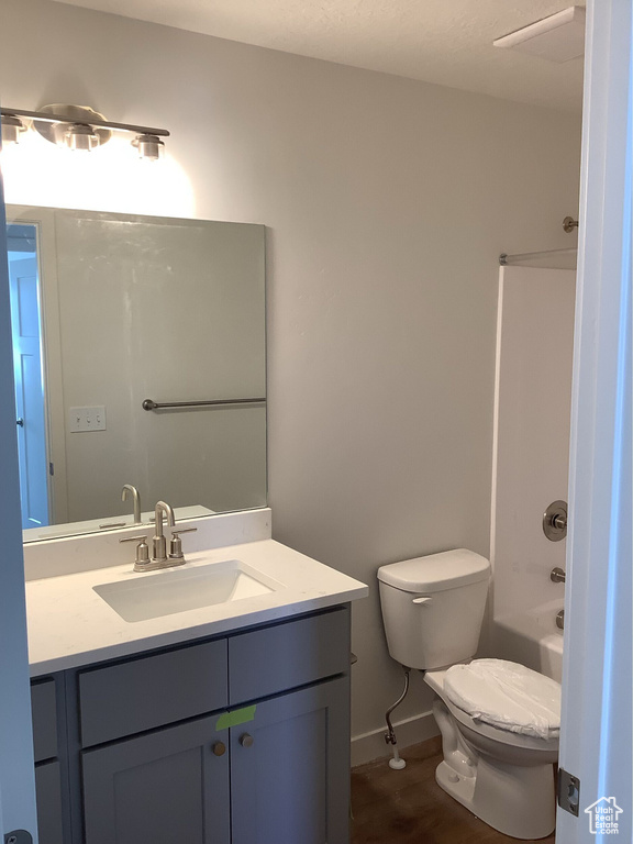 Full bath featuring vanity, toilet, washtub / shower combination, and baseboards