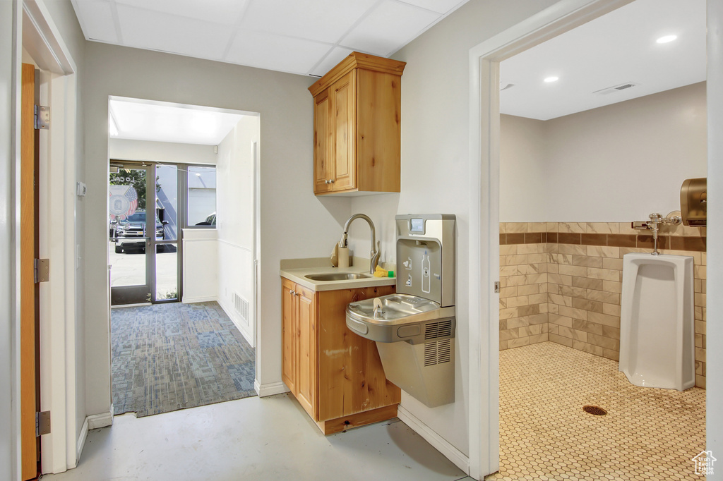 Kitchen featuring sink, tile walls, a paneled ceiling, and light brown cabinets