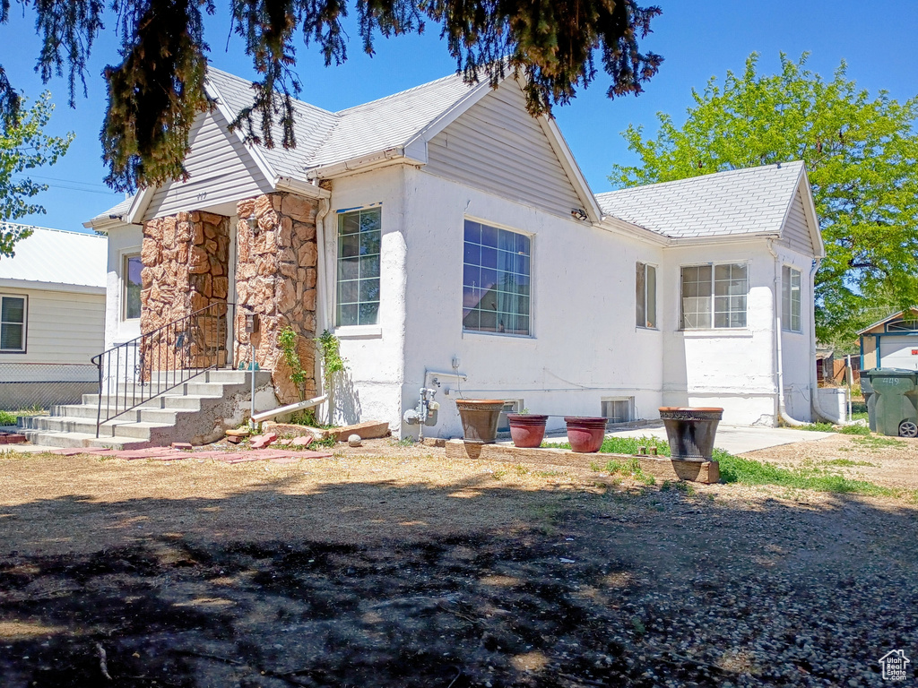 View of front of home featuring stone siding and stucco siding