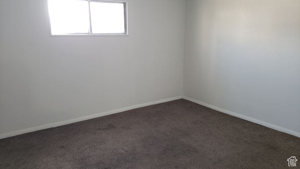 Unfurnished room with dark carpet