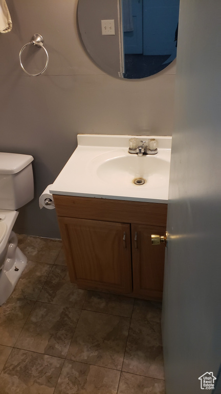 Half bathroom featuring vanity and toilet