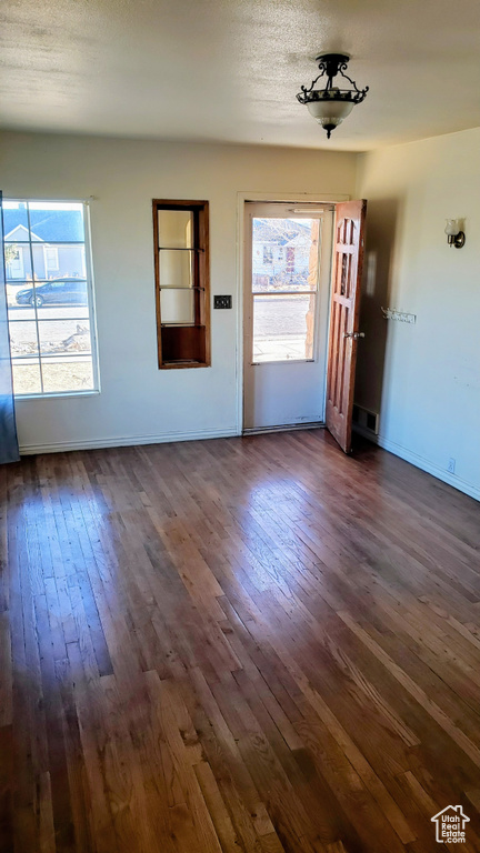 Unfurnished living room with dark wood finished floors and baseboards