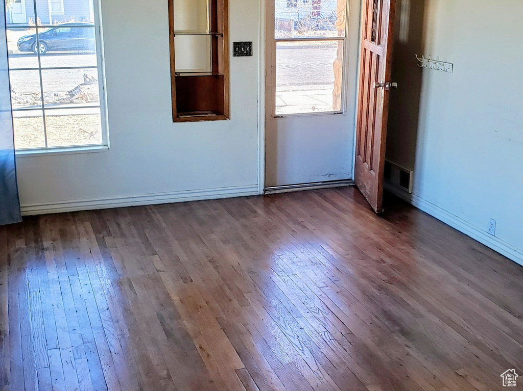 Unfurnished living room with dark wood finished floors and baseboards