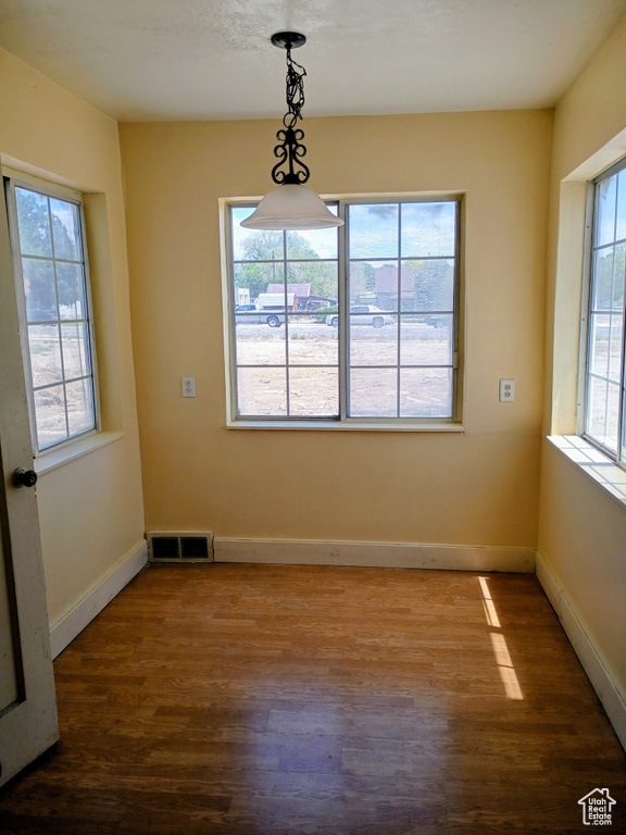 Unfurnished dining area with wood finished floors and baseboards