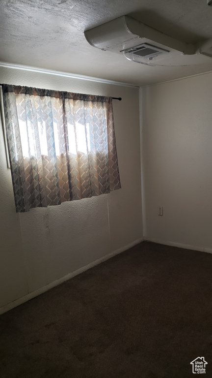 Spare room featuring carpet flooring and baseboards