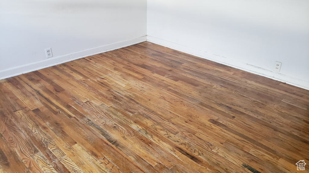 Empty room featuring baseboards and hardwood / wood-style flooring