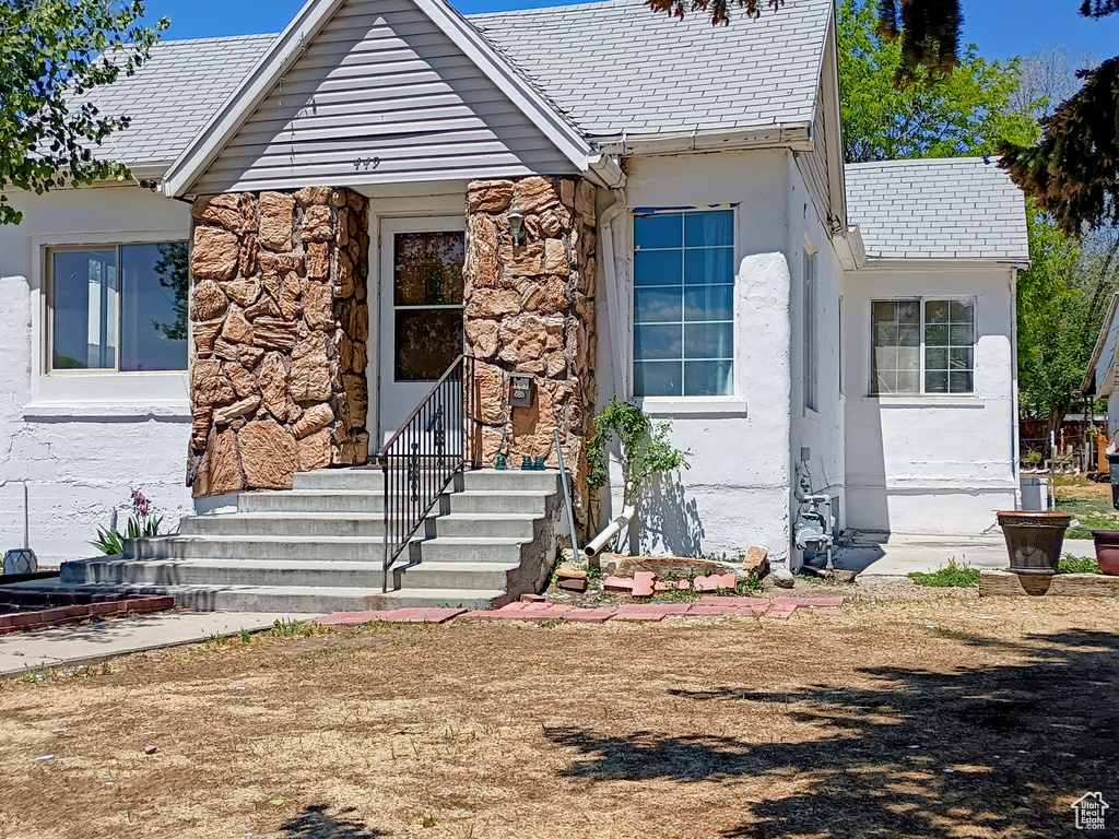 View of front of property featuring stucco siding, a high end roof, and stone siding