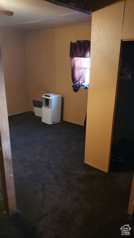 Unfurnished room with dark carpet and a ceiling fan