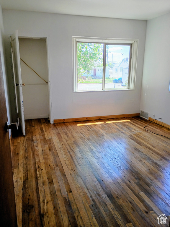 Unfurnished bedroom featuring wood-type flooring and baseboards