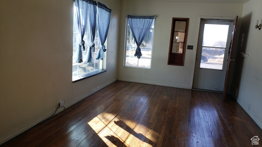 Unfurnished room featuring a healthy amount of sunlight and dark hardwood / wood-style flooring