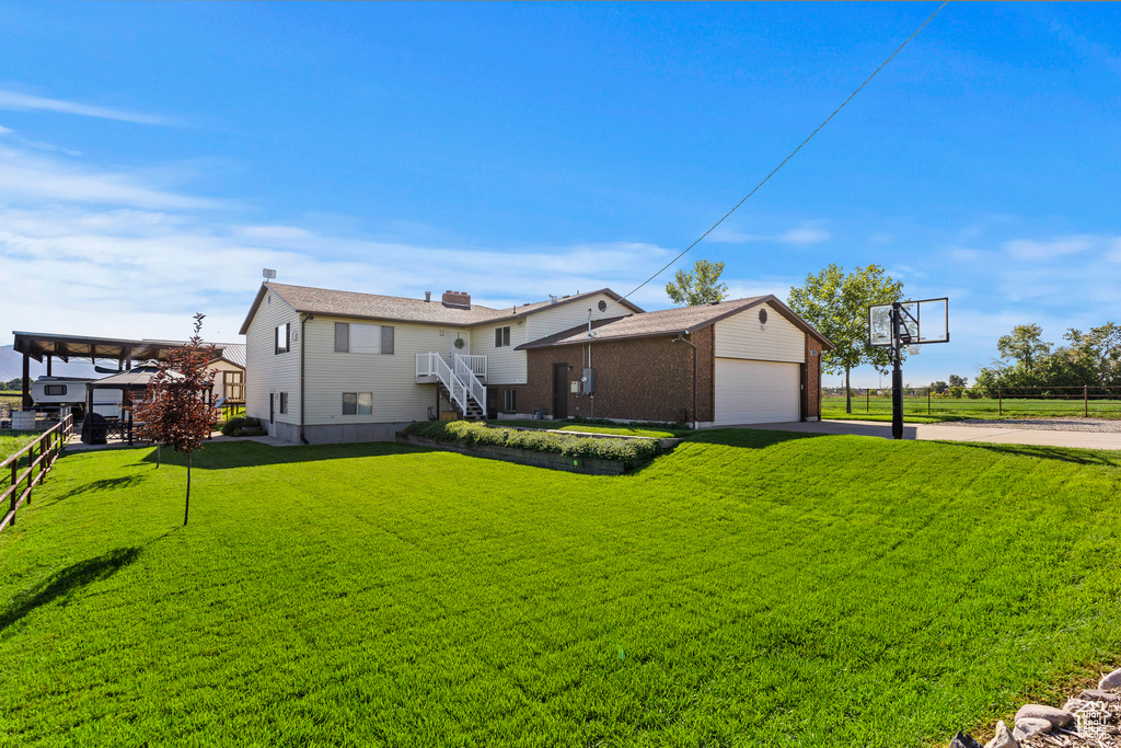 Back of property featuring an outbuilding, a lawn, and a garage
